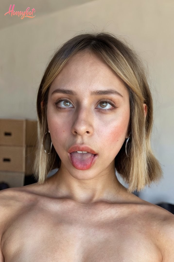 The woman in the picture has short, light brown hair styled in a bob cut. She is wearing small hoop earrings. Her skin appears to be fair, and she has a natural look with minimal …